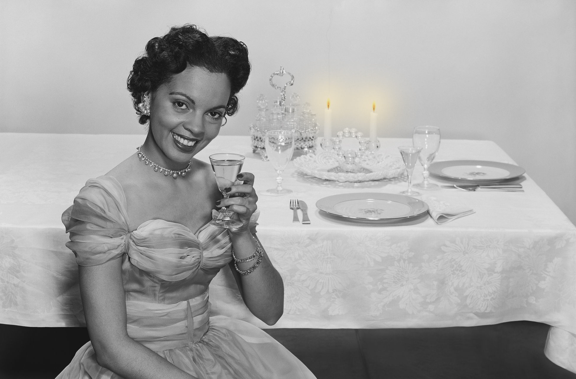 Woman holding glass of drink, smiling, portrait